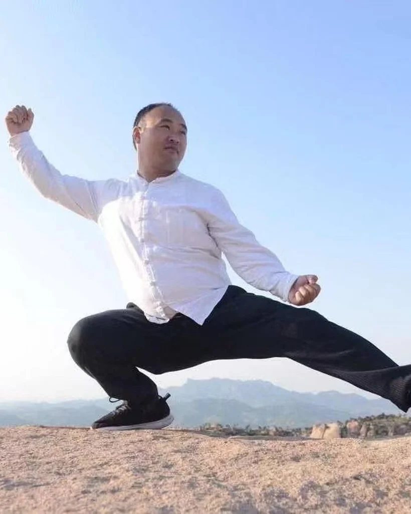 李天金示范弓步左挒定式：前腿弓、后腿蹬，一手横出、一手护中，腰胯折叠
